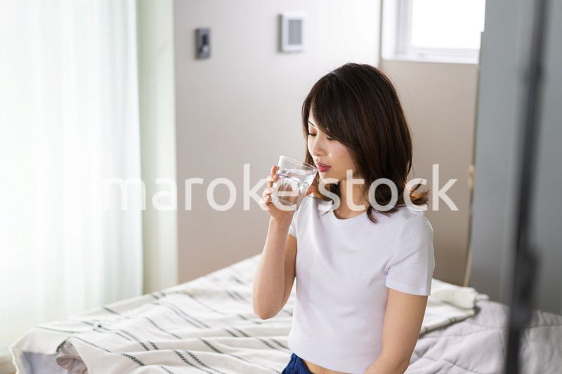 起きて水分補給をする若い女性