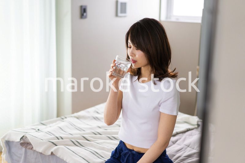 起きて水分補給をする若い女性