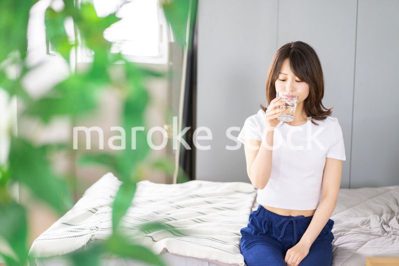 起きて水分補給をする若い女性
