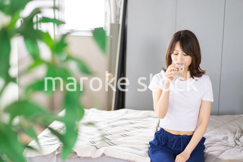 起きて水分補給をする若い女性