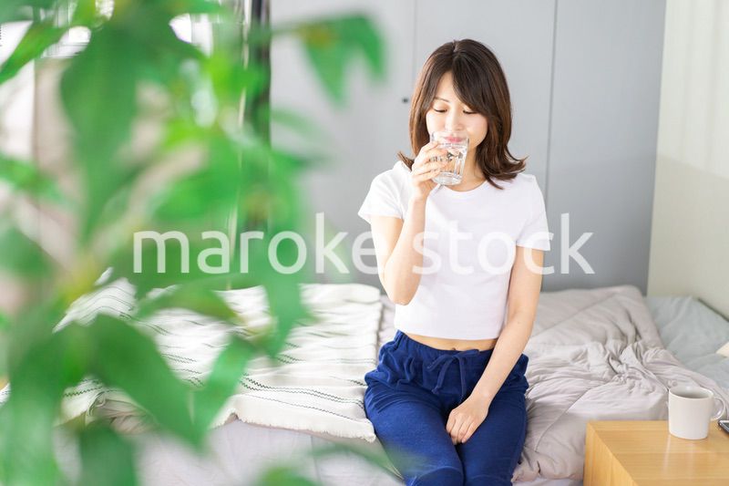 起きて水分補給をする若い女性