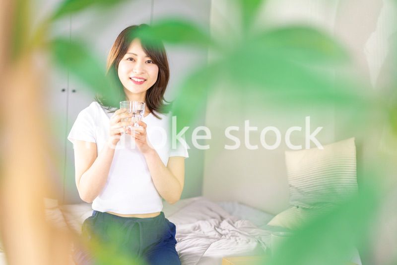 起きて水分補給をする若い女性