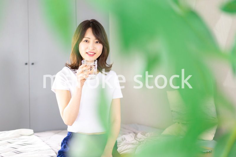 起きて水分補給をする若い女性
