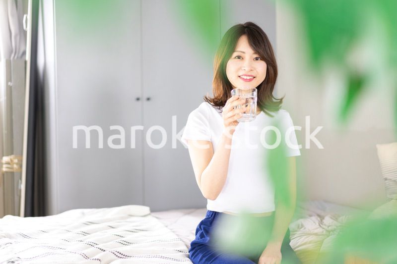 起きて水分補給をする若い女性