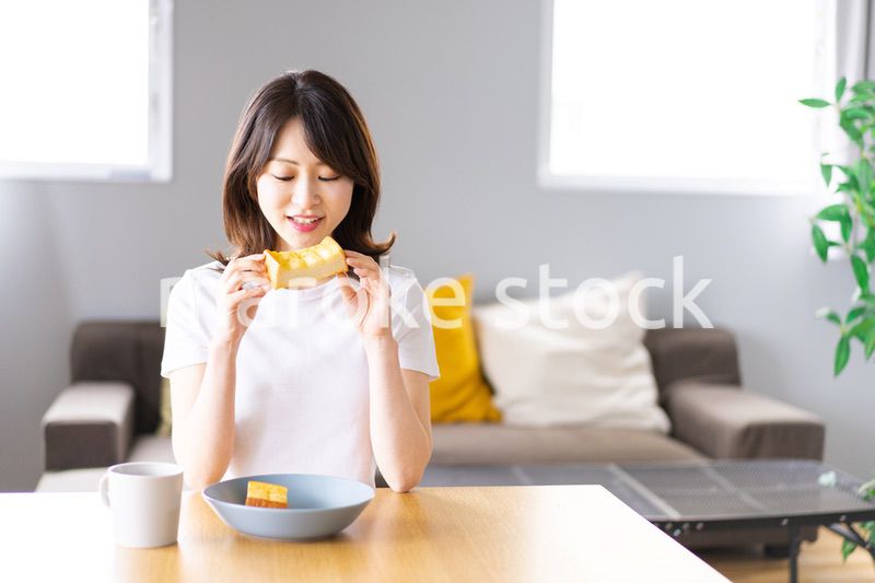 自宅で朝食を食べる若い女性