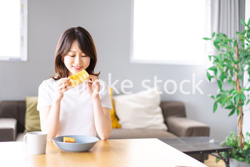 自宅で朝食を食べる若い女性