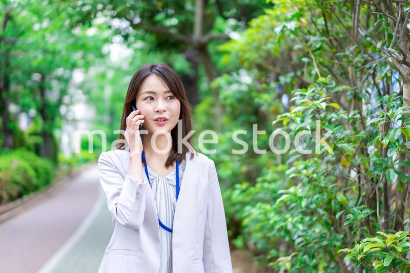 外で電話をするビジネスウーマン