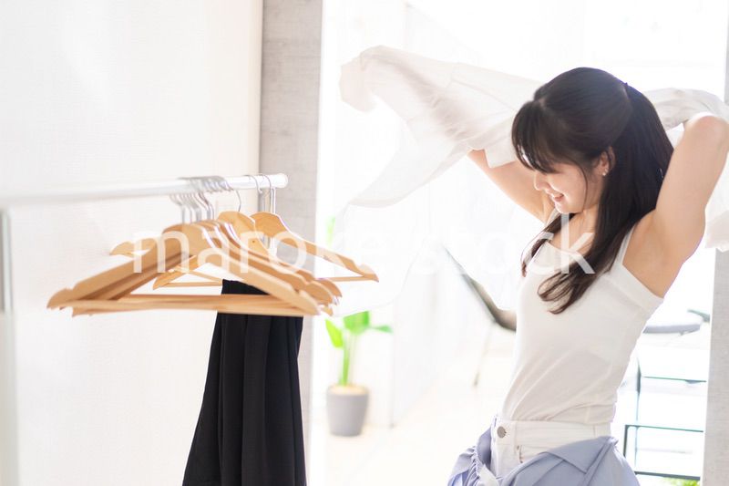 部屋で着替える若い女性