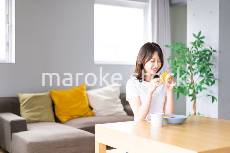 自宅で朝食を食べる若い女性