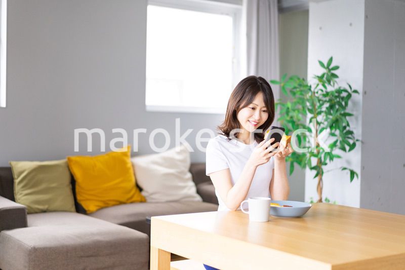 自宅で朝食を食べる若い女性