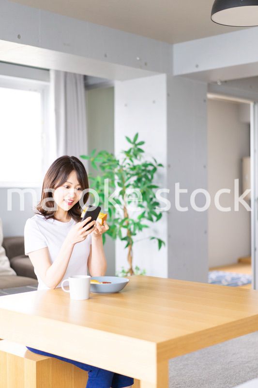 自宅で朝食を食べる若い女性