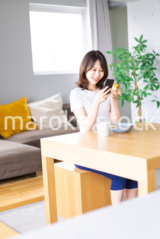 自宅で朝食を食べる若い女性