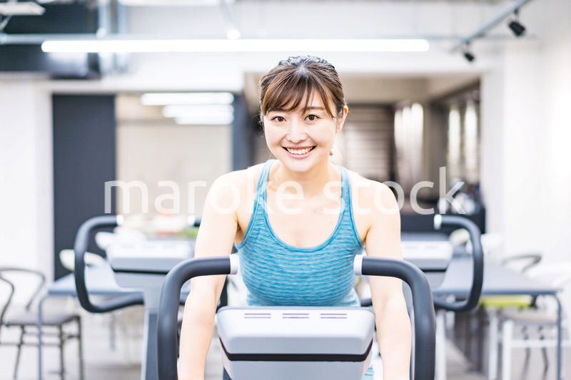 ジムでマシーントレーニングをする若い女性