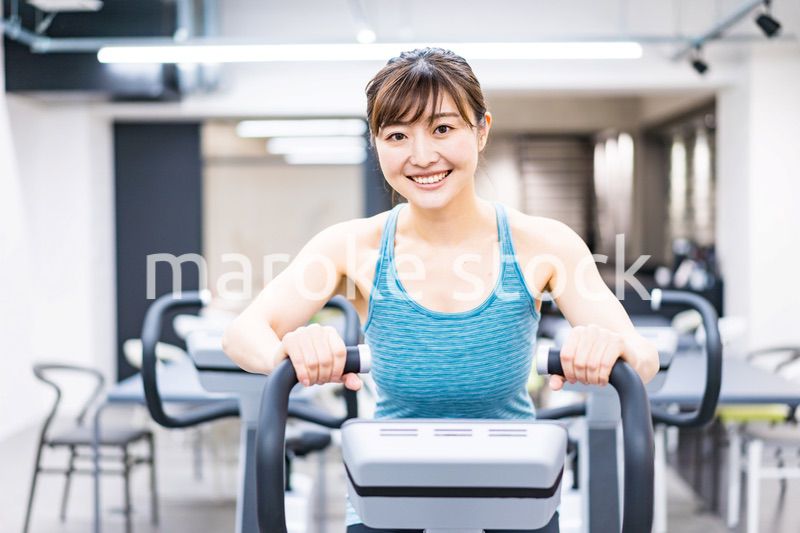 ジムでマシーントレーニングをする若い女性