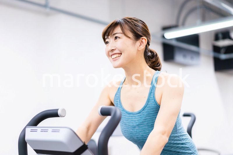 ジムでマシーントレーニングをする若い女性