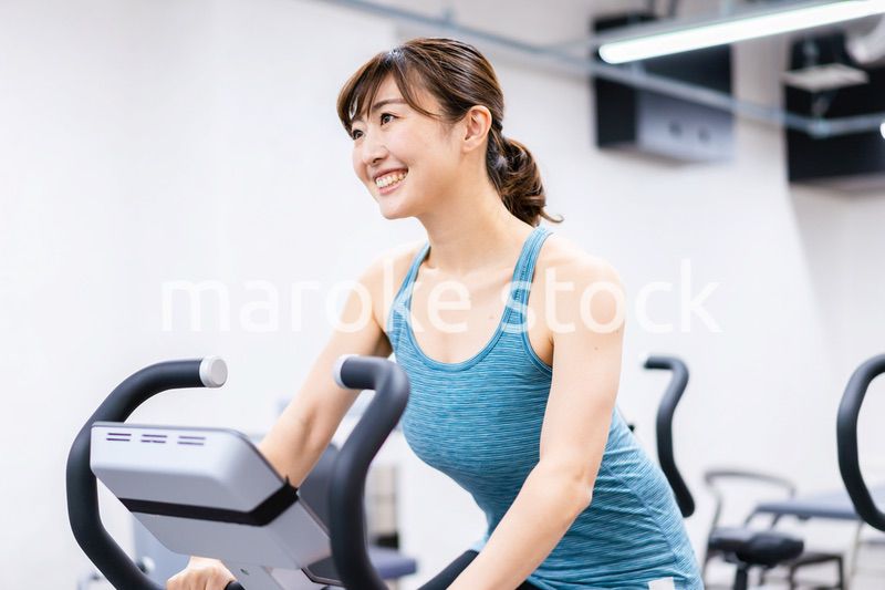 ジムでマシーントレーニングをする若い女性