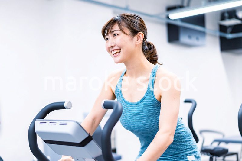 ジムでマシーントレーニングをする若い女性