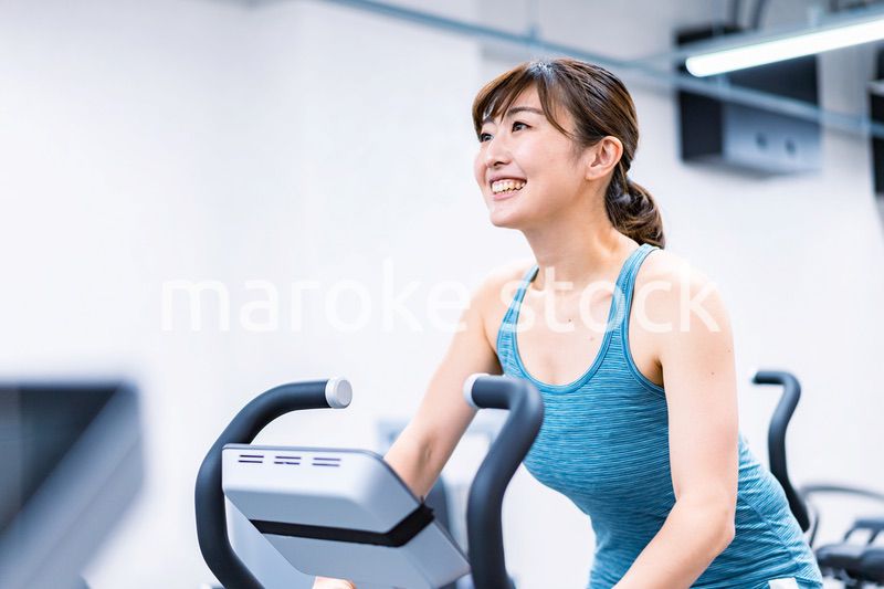 ジムでマシーントレーニングをする若い女性