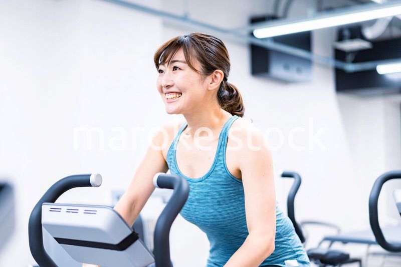 ジムでマシーントレーニングをする若い女性