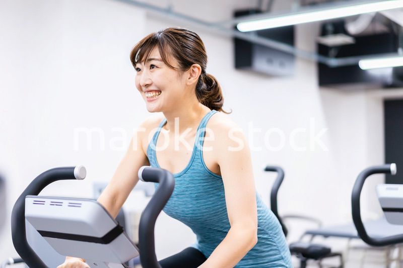 ジムでマシーントレーニングをする若い女性