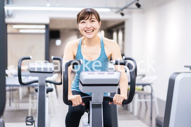 ジムでマシーントレーニングをする若い女性