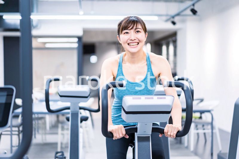 ジムでマシーントレーニングをする若い女性