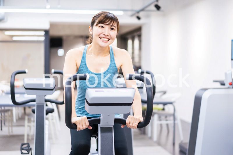 ジムでマシーントレーニングをする若い女性