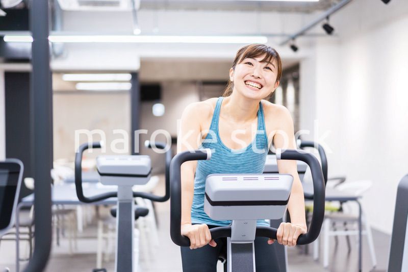 ジムでマシーントレーニングをする若い女性