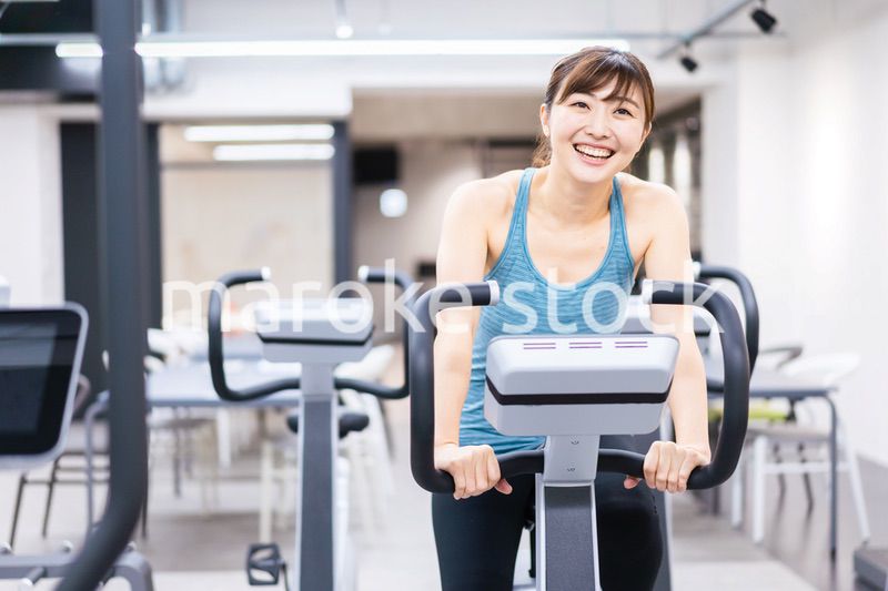 ジムでマシーントレーニングをする若い女性