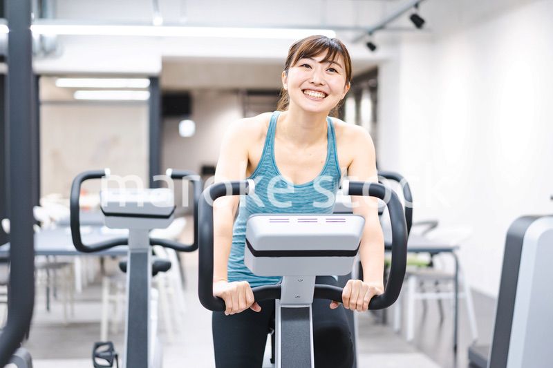 ジムでマシーントレーニングをする若い女性