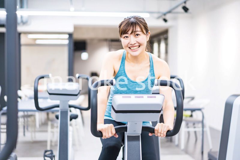 ジムでマシーントレーニングをする若い女性