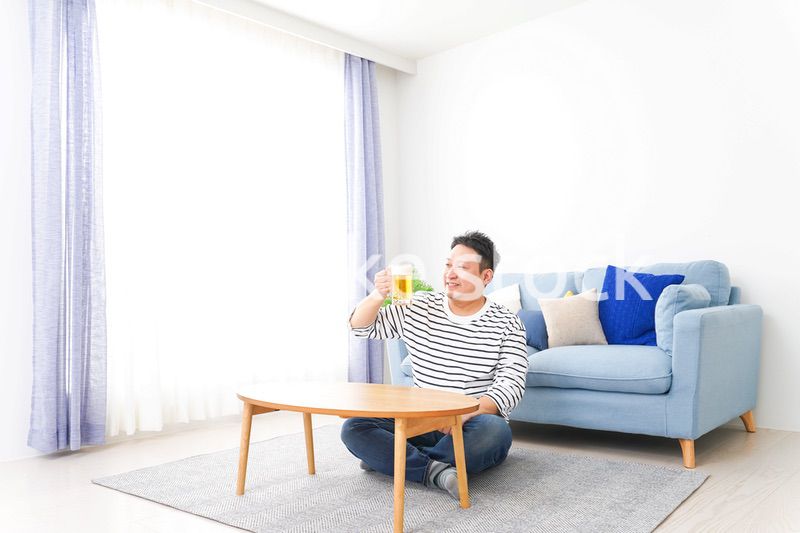 自宅でビールを飲む中年の男性