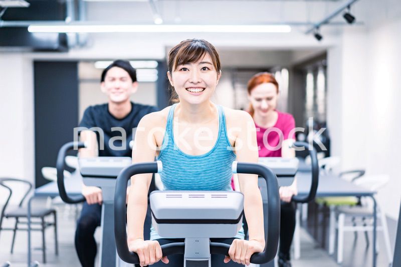 自転車マシンでトレーニングをする人々