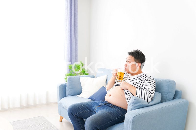 自宅でビールを飲む中年の男性