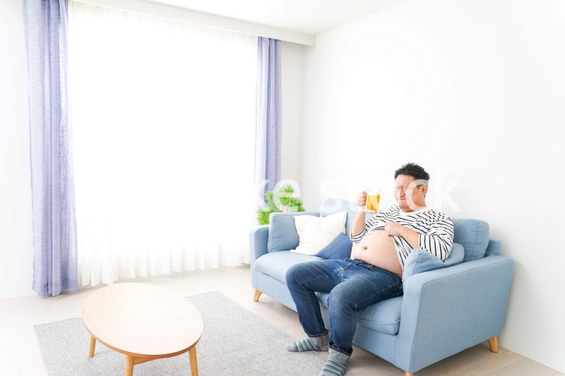 自宅でビールを飲む中年の男性