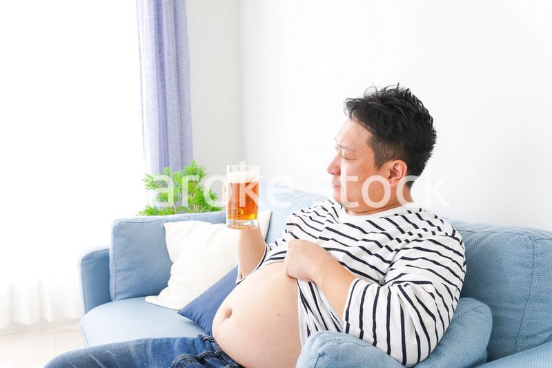 自宅でビールを飲む中年の男性