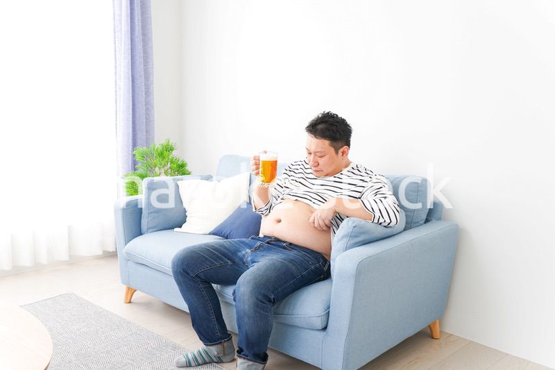 自宅でビールを飲む中年の男性