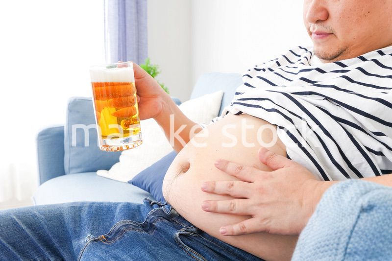 自宅でビールを飲む中年の男性
