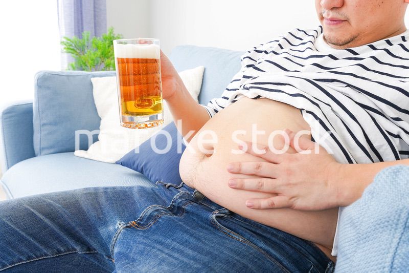 自宅でビールを飲む中年の男性