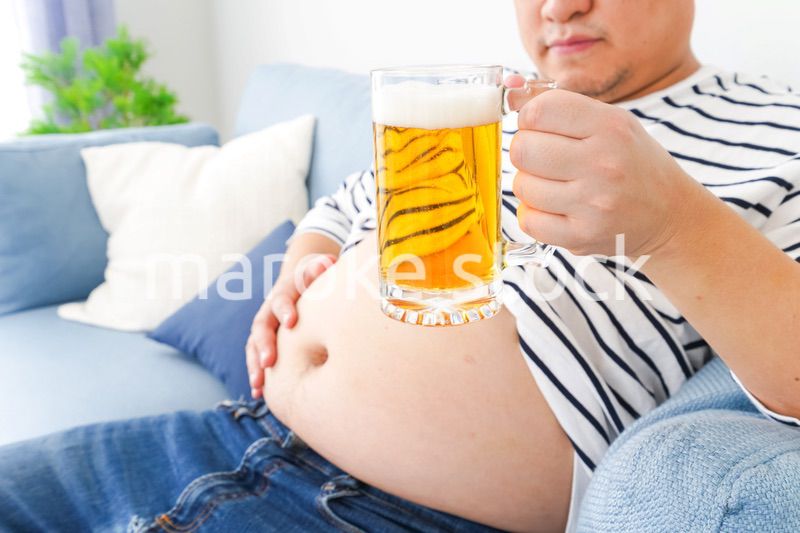 自宅でビールを飲む中年の男性