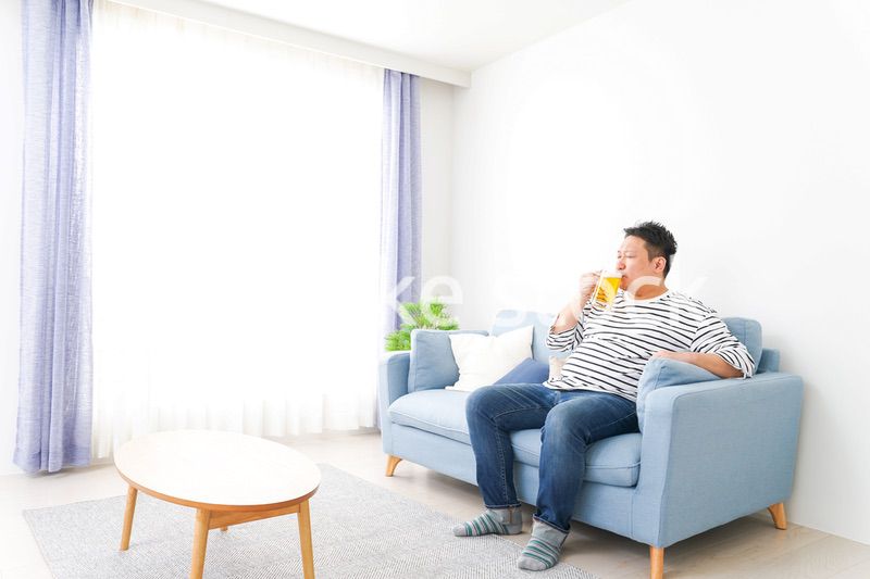 自宅でビールを飲む中年の男性