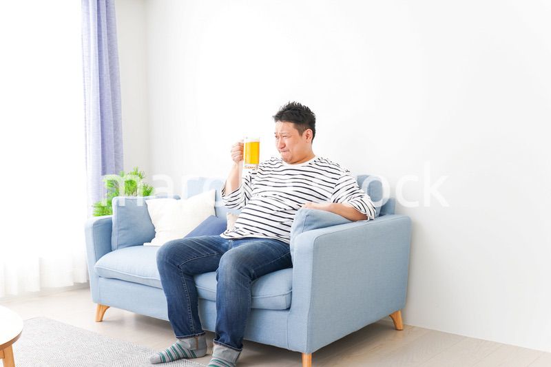 自宅でビールを飲む中年の男性