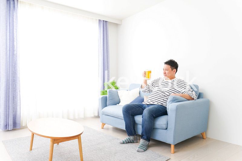 自宅でビールを飲む中年の男性