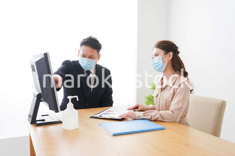 感染症対策をしてオフィスで働くビジネスパーソン