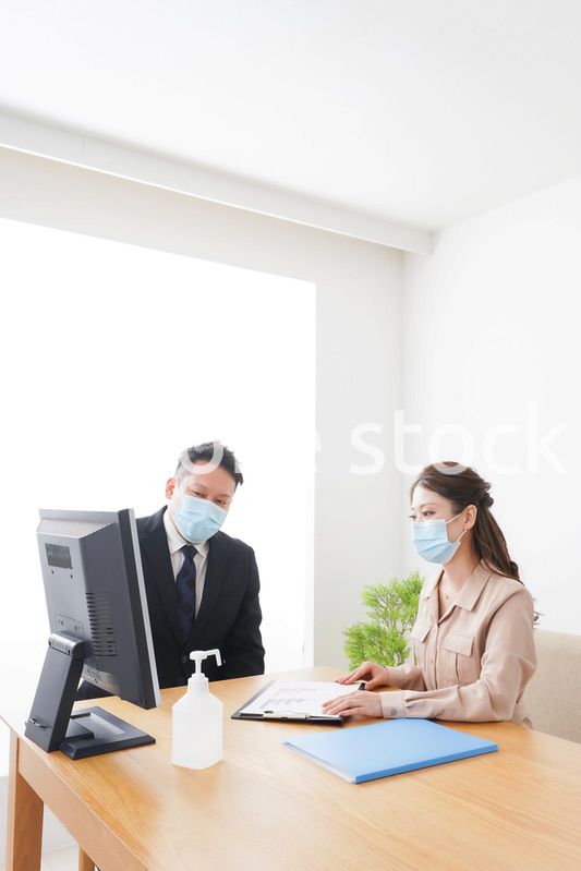 感染症対策をしてオフィスで働くビジネスパーソン