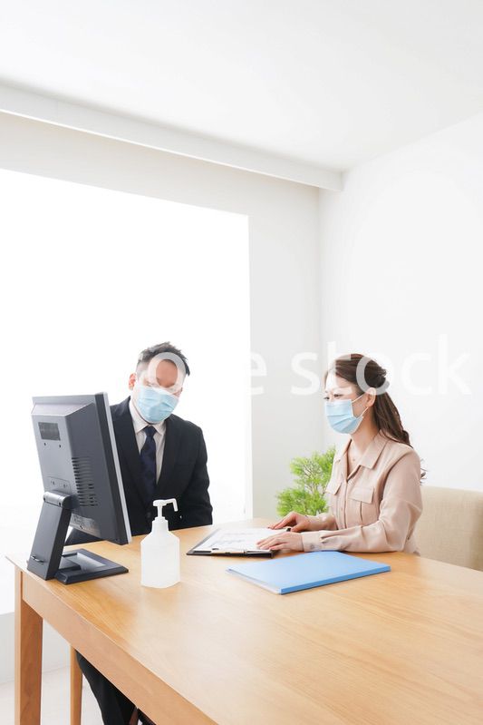 感染症対策をしてオフィスで働くビジネスパーソン