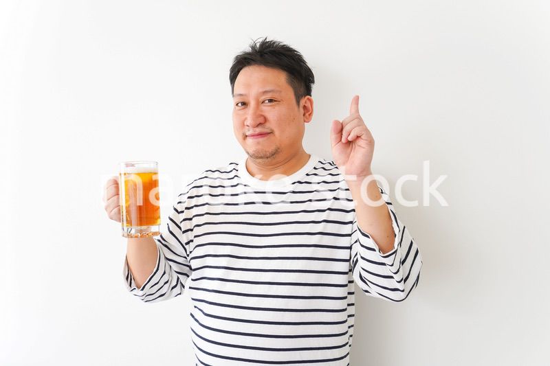 自宅でビールを飲む中年の男性