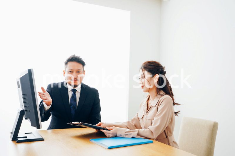 オフィスで仕事をする2人のビジネスパーソン