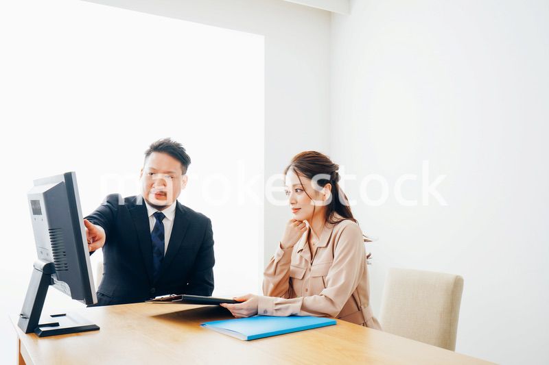 オフィスで仕事をする2人のビジネスパーソン