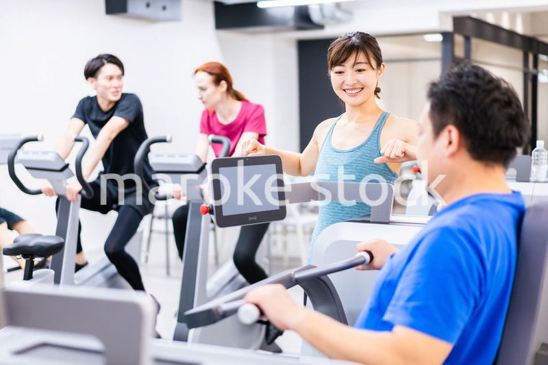 ジムでパーソナルトレーニングを受ける中年男性